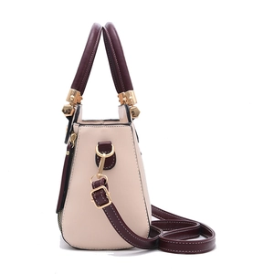 Fashionable off-white and burgundy leather handbag with gold hardware and shoulder strap