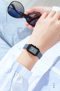 Donna elegante che indossa un orologio al quarzo quadrato con quadrante blu minimalista