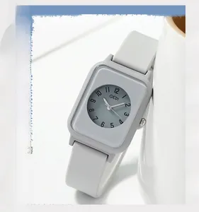 Minimalist grey quartz watch with silicone strap resting against a ceramic cup