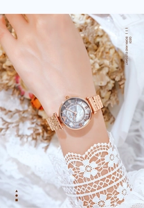 Detailed view of women's watch with rose gold mesh strap and grey marble diamond dial