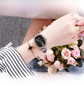 Close-up of vintage silver ladies watch with diamond-set bezel and black oval dial