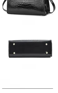 Detail view of the black crocodile pattern handbag back and bottom with gold feet