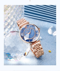 Detail of rose gold quartz watch with blue dial and diamond-set center ring