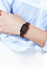 Primo piano dell'orologio al quarzo rettangolare minimalista con cinturino marrone al polso