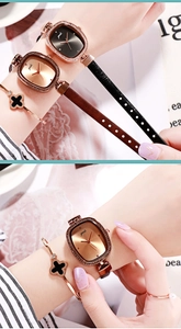 Close-up of elegant oval diamond watch with clover bracelet set on woman's wrist