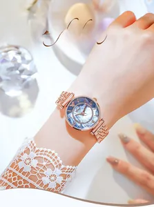 Close-up of rose gold steel watch with blue gradient dial and rhinestone bezel on wrist