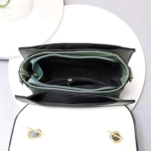 Minimalist green small square bag showing three internal storage compartments and zipper