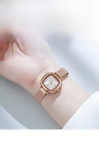 Close-up of minimalist rose gold mesh strap watch for women with silver-white dial