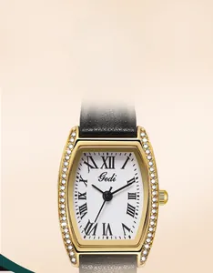 Detail of tonneau gold watch case with crystal inlay and Roman numeral dial