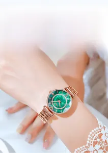 Detail of rose gold steel watch with green multifaceted dial and crystal indexes