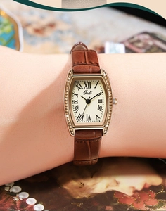 Macro detail of tonneau-shaped watch case with sparkling crystals and Roman numerals