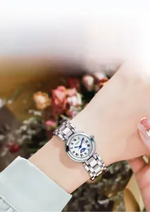 Détail de la montre femme en acier argenté avec chiffres romains et affichage calendrier