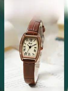 Detail of rose gold tonneau watch case with crystal accents and Roman numeral dial