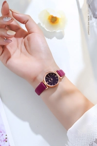 Detail shot of GEDI women's star dial watch with purple leather strap on model wrist