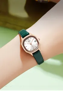 Close-up of Gedi rose gold tonneau watch with green leather strap and date display