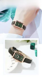 Détail de la montre rectangulaire or rose avec cadran vert et bracelet en cuir sur support
