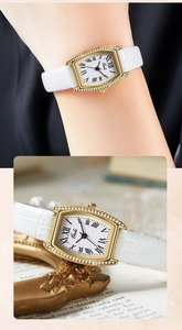 Detailed view of women's tonneau-shaped quartz watch with Roman numerals and diamond bezel