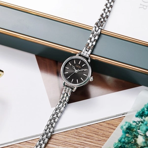 Montre femme minimaliste en argent avec cadran noir sur une boîte à bijoux élégante