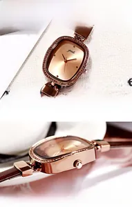 Detail of rose gold oval watch with crystal bezel and mineral glass surface