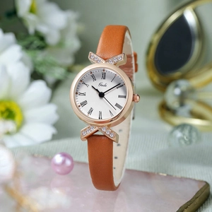 Elegant ladies' rose gold watch with brown leather strap and diamond bow lugs