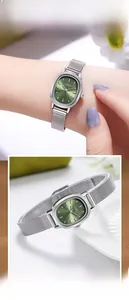 Detail of elegant silver mesh strap and oval emerald green dial of a luxury women watch