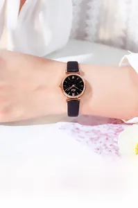 Close-up of rose gold starry sky watch with black leather strap on a female wrist
