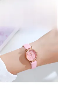 Close-up of pink marble dial watch with rose gold case and leather strap on a model's wrist
