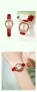 Macro detail of gold square watch case with red leather strap and calendar date display