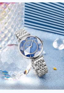 Macro view of blue marble dial with rhinestone bezel and silver steel watch band