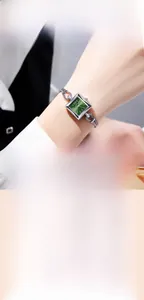 Detail van GEDI kwartshorloge met smaragdgroene wijzerplaat en zilveren metalen band
