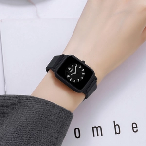 Black minimalist rectangular silicone quartz watch with white numerals on a wrist