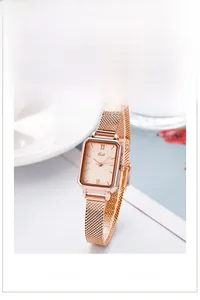 Detail of elegant rectangular rose gold quartz watch with a refined Milanese mesh strap