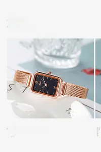 Close-up of elegant rose gold square quartz watch with black starry dial on ceramic tray