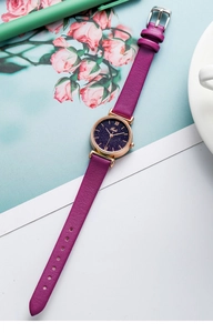 Detailed close-up of a women's purple quartz watch with a starry blue dial and gold case