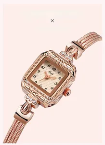 Close-up of vintage square watch with rose gold engraved patterns and rhinestone accents