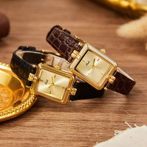 Orologio da donna vintage quadrato con quadrante dorato e cinturino in pelle su legno