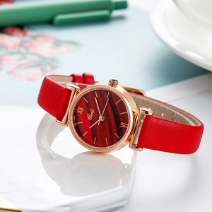 Women's star quartz watch with red leather strap and rose gold case on marble
