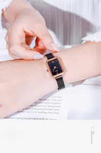 Detail of elegant rectangular rose gold watch with black starry dial on model wrist