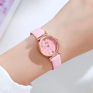 Women's quartz watch with pink leather strap and rose gold marble dial worn on wrist
