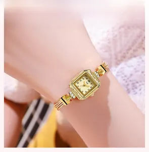 Detailed macro of a vintage gold square watch with crystal bezel and mesh chain strap