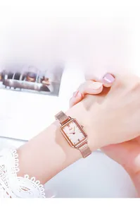 Close-up of a women's vintage square quartz watch with rose gold mesh strap on wrist