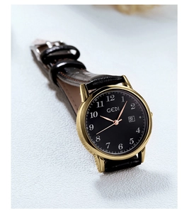Detailed close-up of a vintage leather strap watch with a golden stainless steel case