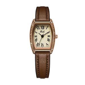 Detail of rose gold tonneau watch case with rhinestones and brown leather strap