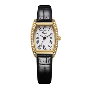 Close-up of golden tonneau watch case with sparkling rhinestones and roman dial