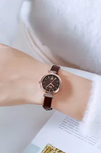 Detail einer eleganten Damenuhr mit braunem Lederarmband und roségoldener Kristalllünette