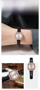 Detail of rose gold octagonal quartz watch with silver dial and black leather strap