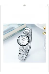 Détail d'une montre à quartz blanche avec bracelet en acier argenté sur des livres déco