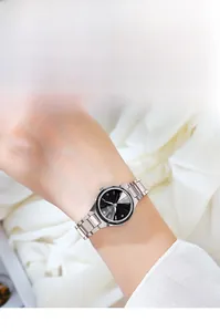 Gros plan d'une montre en acier argenté avec cadran en strass noir sur un poignet