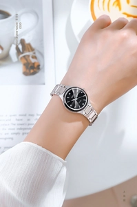 Montre quartz femme élégante avec cadran noir et bracelet en métal argenté au poignet