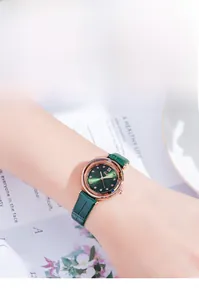 Detail of a vintage quartz watch with a green leather strap and rose gold case on a wrist
